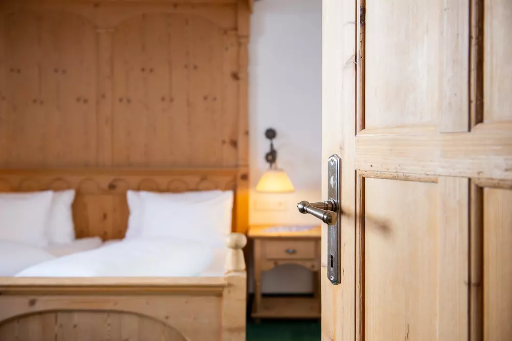 Blick von der Eingangstür in ein Hotelzimmer mit Doppelbett aus Holz
