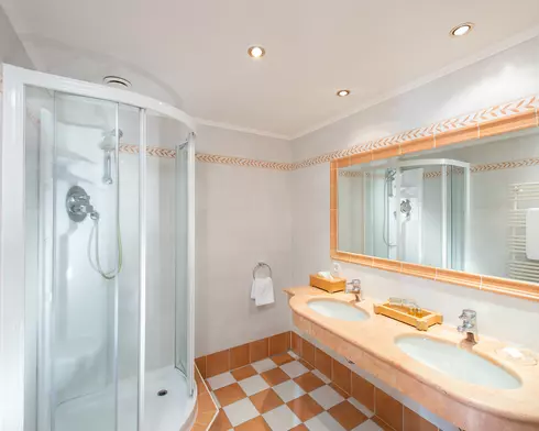 Bad mit geräumiger Dusche, großem Wandspiegel und Doppelwaschbecken