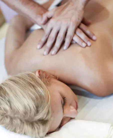 Frau bei einer Rückenmassage auf einem Massagetisch