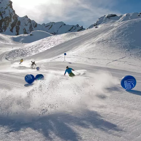 Skifahrer auf einer frisch präparierten Skipiste im Winter bei Sonnenschein